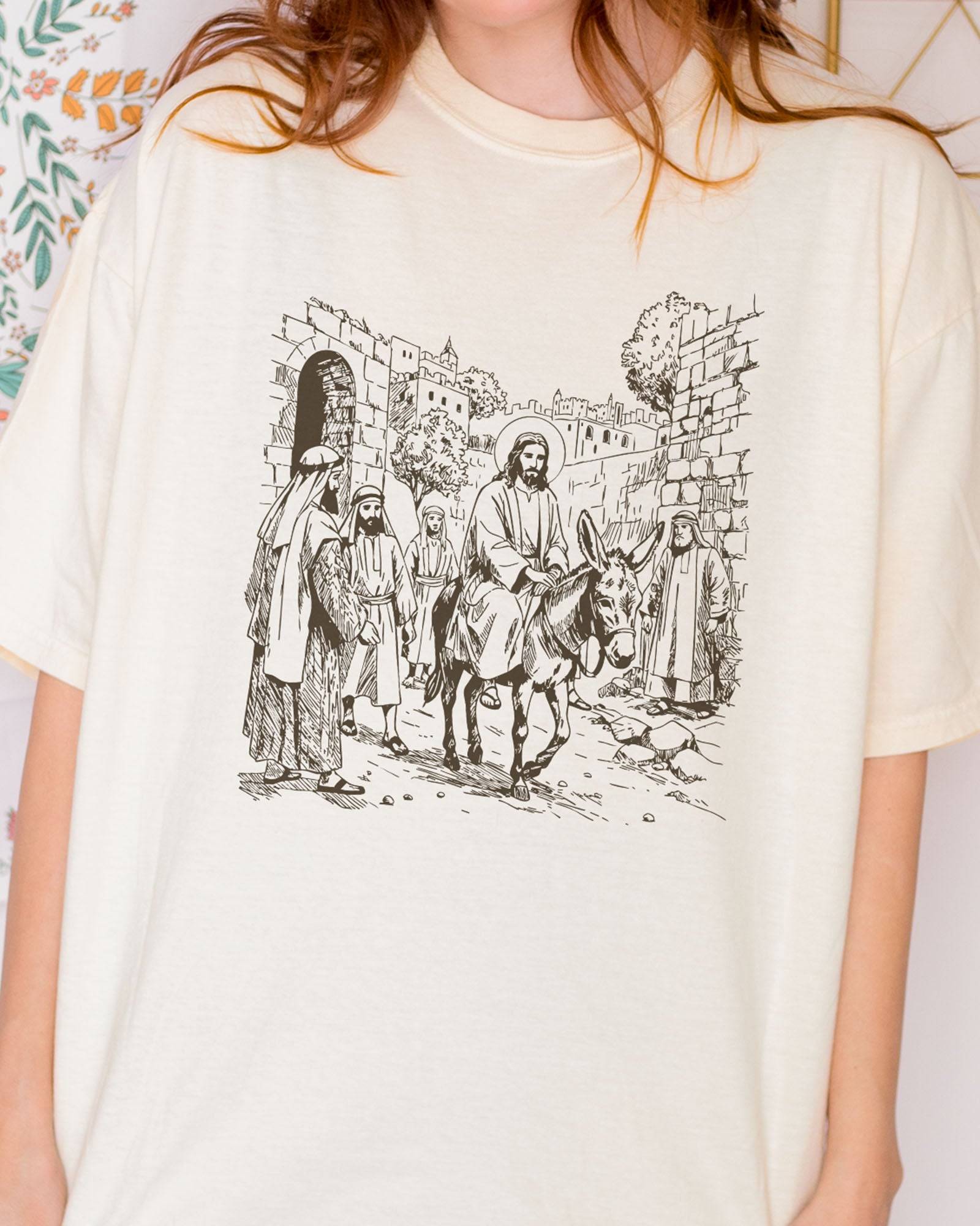 Close-up of model wearing ivory color shirt with Jesus Riding Donkey christian graphic design