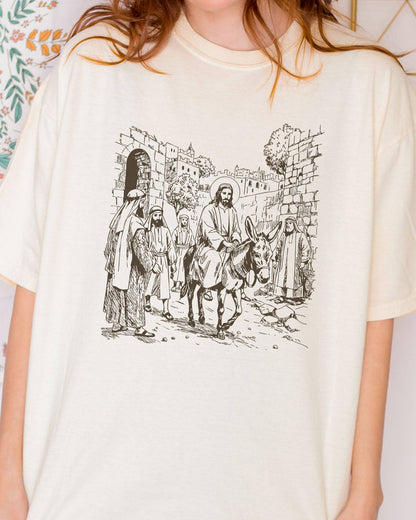 Close-up of model wearing ivory color shirt with Jesus Riding Donkey christian graphic design
