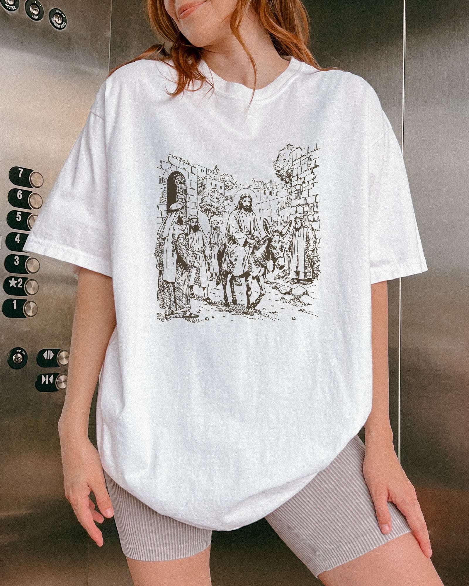 Model wearing white color shirt with Jesus Riding Donkey christian graphic design