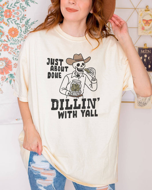 Model wearing ivory color shirt with 'Just About Done Dillin With Yall' funny cowboy skeleton pickle graphic design
