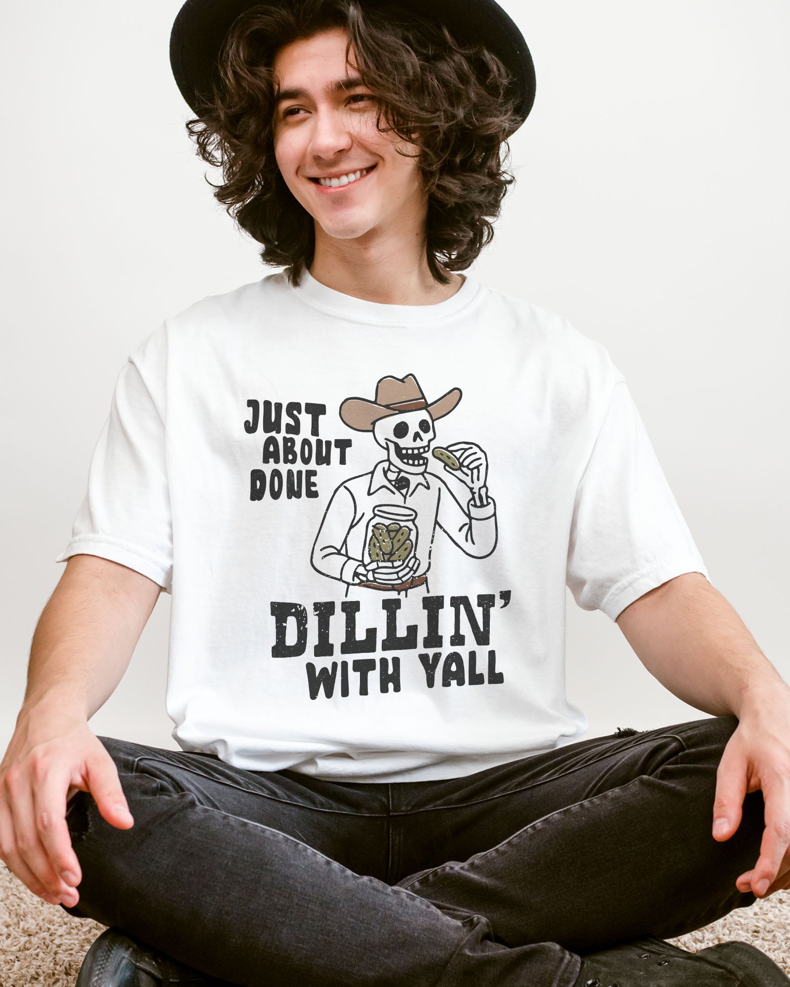 Model wearing white color shirt with 'Just About Done Dillin With Yall' funny cowboy skeleton pickle graphic design