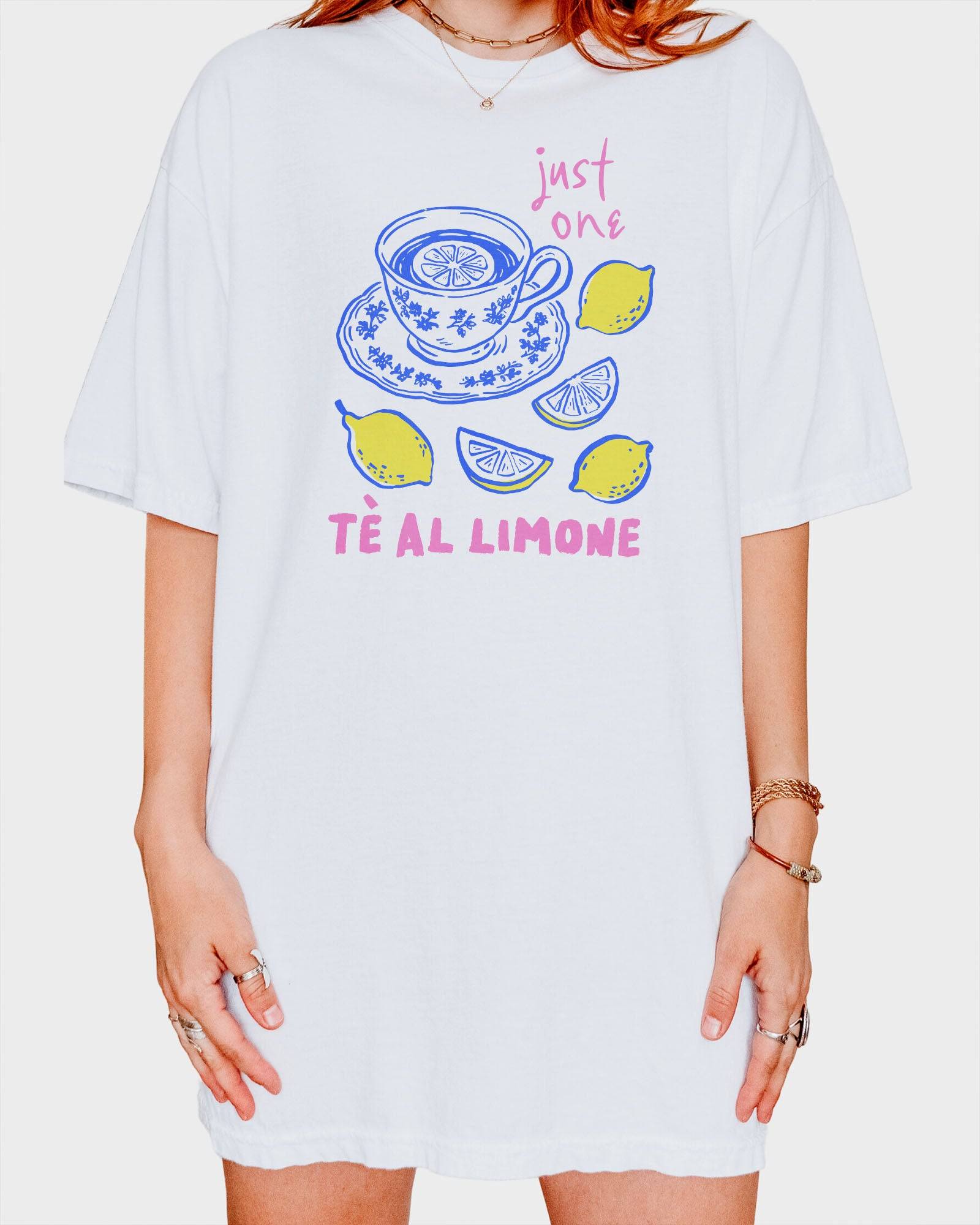 Woman wearing a white “Just One Té Al Limone” shirt with a retro graphic of a steaming cup of lemon tea and fresh lemons.