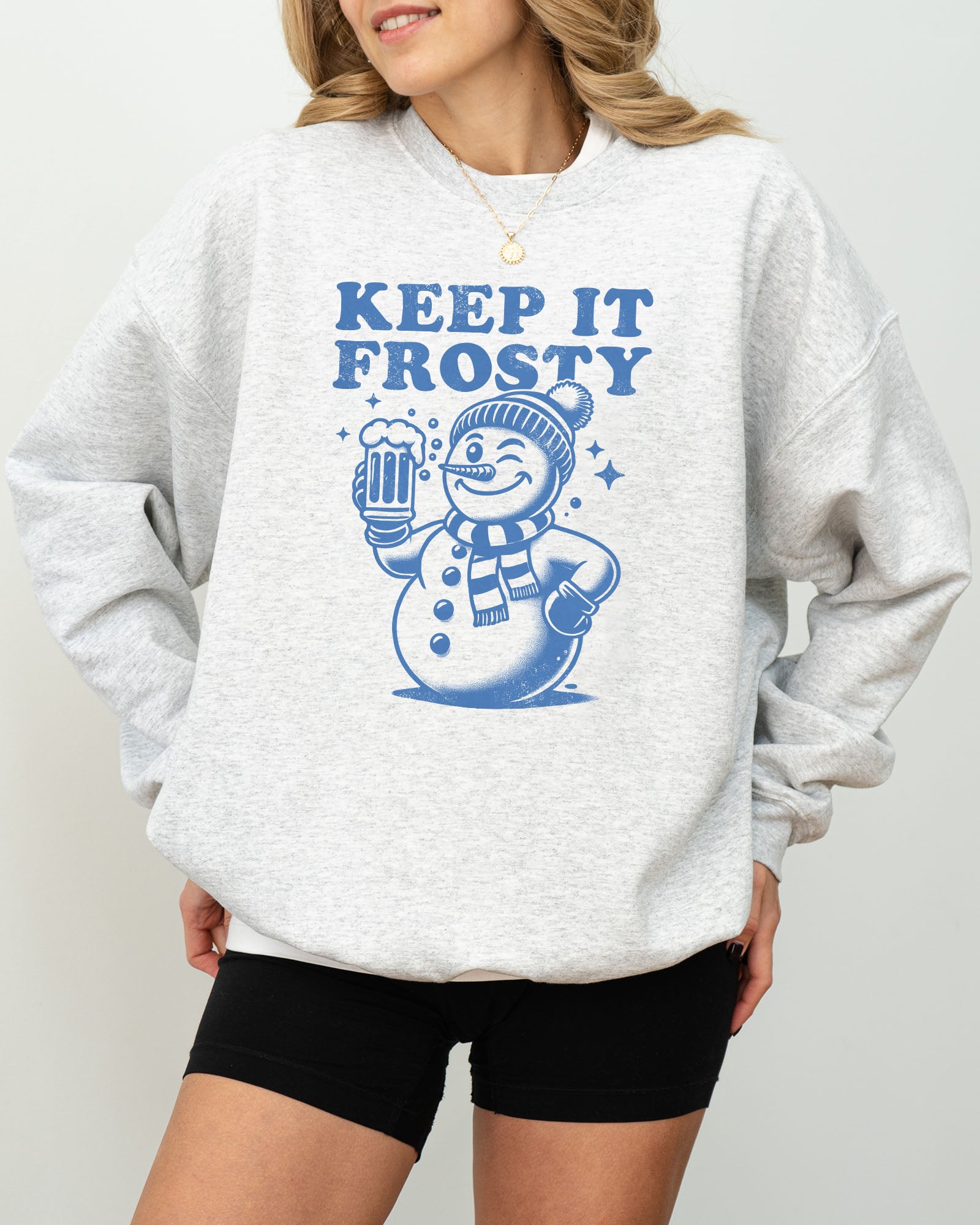 Model wearing ash color sweatshirt with 'Keep It Frosty' snowman graphic design