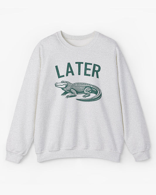 Flat lay unisex ash-colored 'Later Gator' sweatshirt featuring a funny retro alligator graphic.