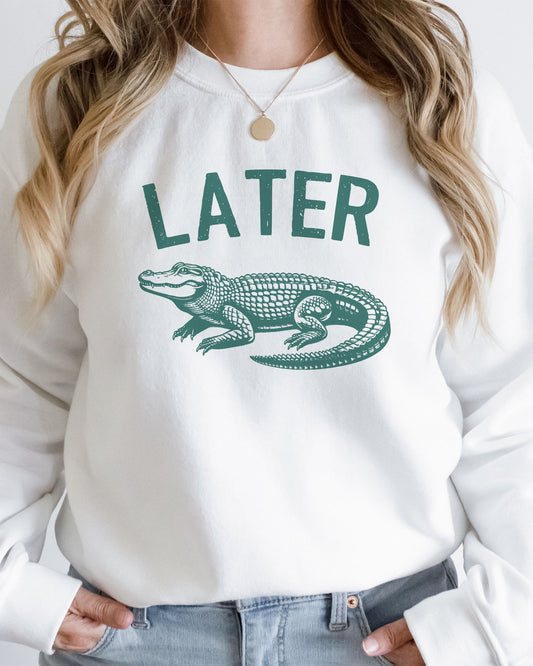 Woman wearing unisex white-colored 'Later Gator' sweatshirt featuring a funny retro alligator graphic.