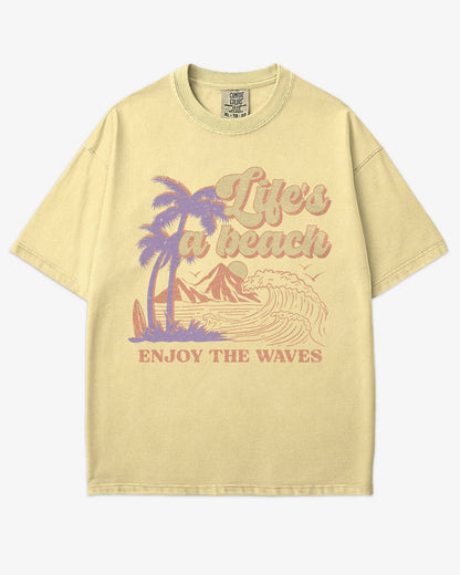 Life’s A Beach – Enjoy The Waves retro surf graphic t-shirt in butter with beach and waves design.