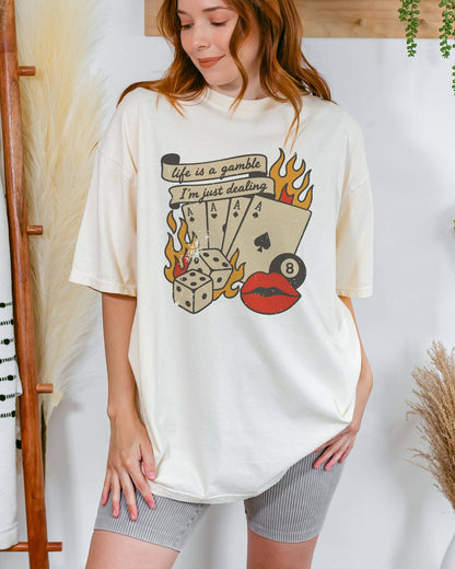 Model wearing ivory color shirt with 'Life Is A Gamble, I'm Just Dealing' retro poker and gambling graphic design