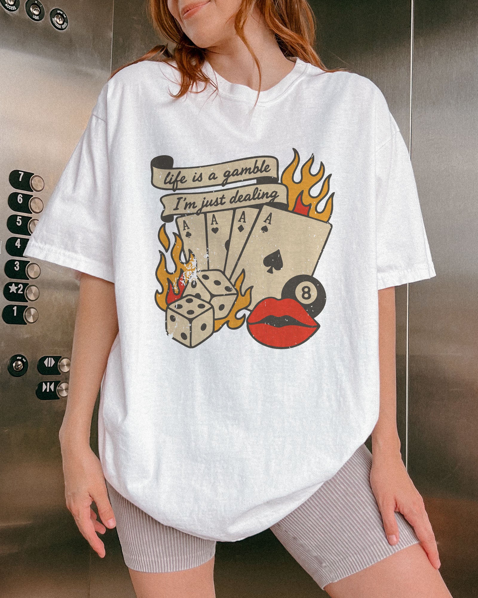 Woman wearing white color shirt with 'Life Is A Gamble, I'm Just Dealing' retro poker and gambling graphic design