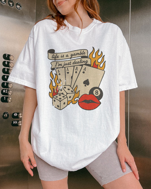 Woman wearing white color shirt with 'Life Is A Gamble, I'm Just Dealing' retro poker and gambling graphic design