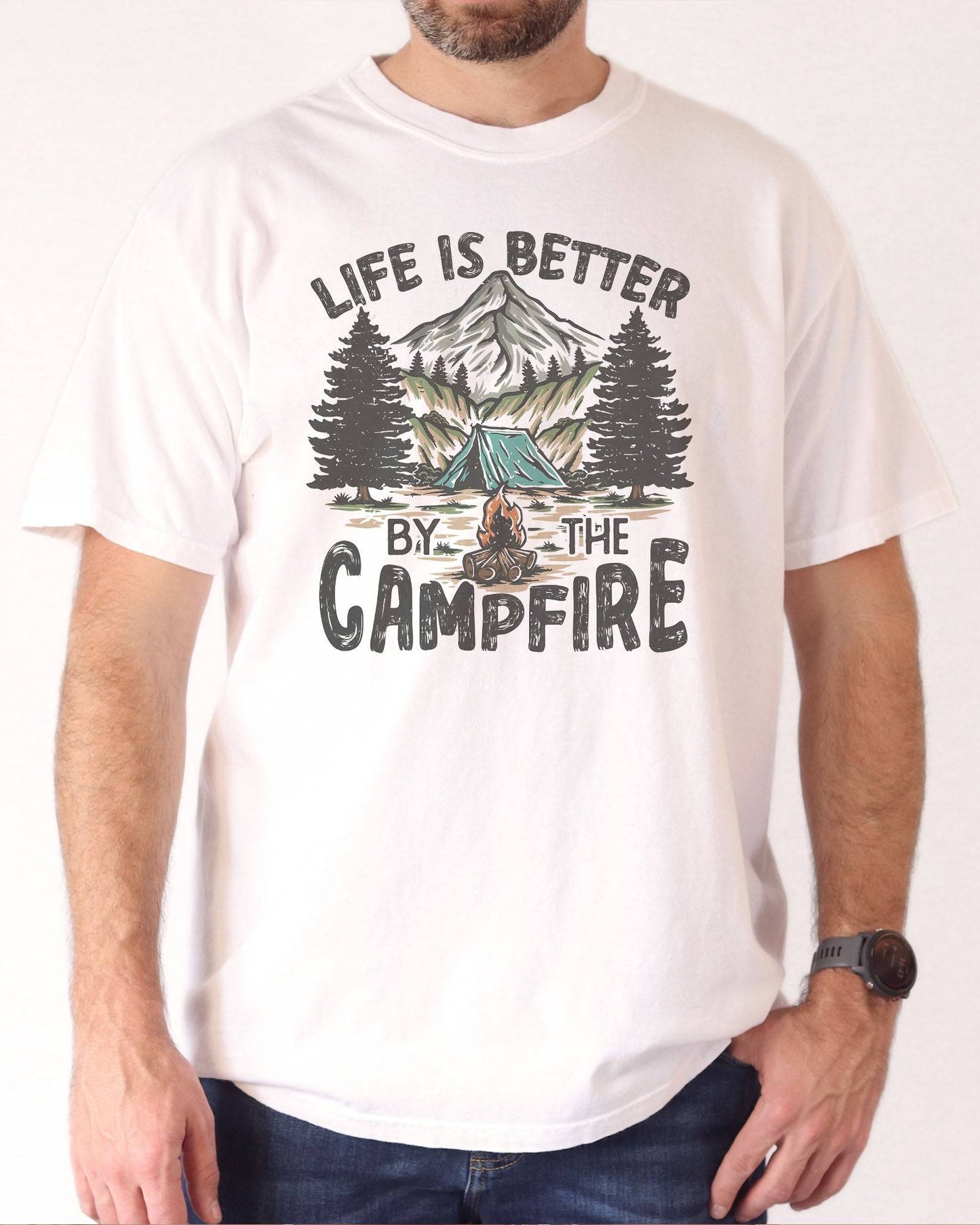 Man wearing 'Life Is Better By The Campfire' shirt in white color and with  retro camping nature graphic