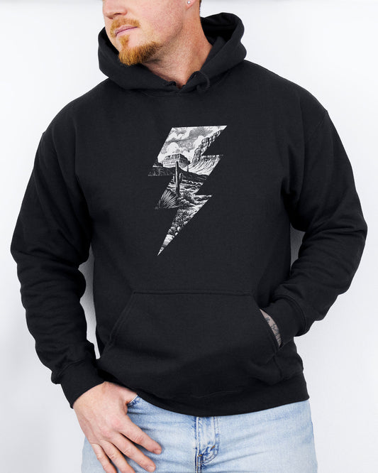 Man wearing a black hoodie featuring a retro vintage-style western desert scenery lightning bolt graphic.