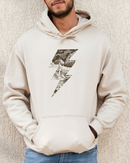 Man wearing a sand beige hoodie featuring a retro vintage-style western desert scenery lightning bolt graphic.