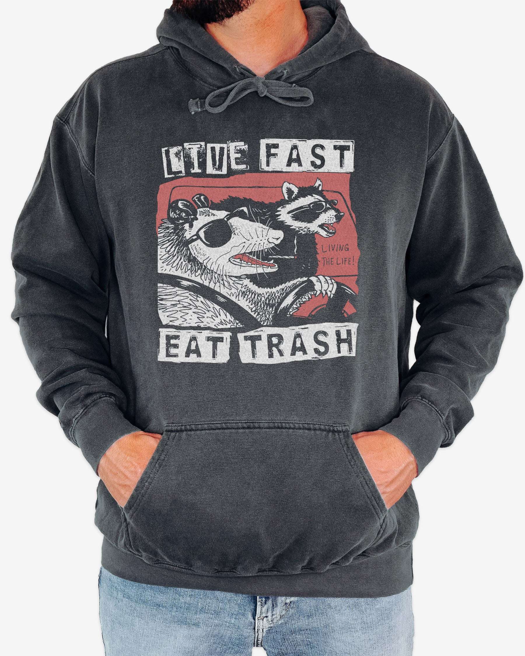 Man wearing pepper 'Live Fast Eat Trash' hoodie with a funny retro graphic of two raccoons driving a car.