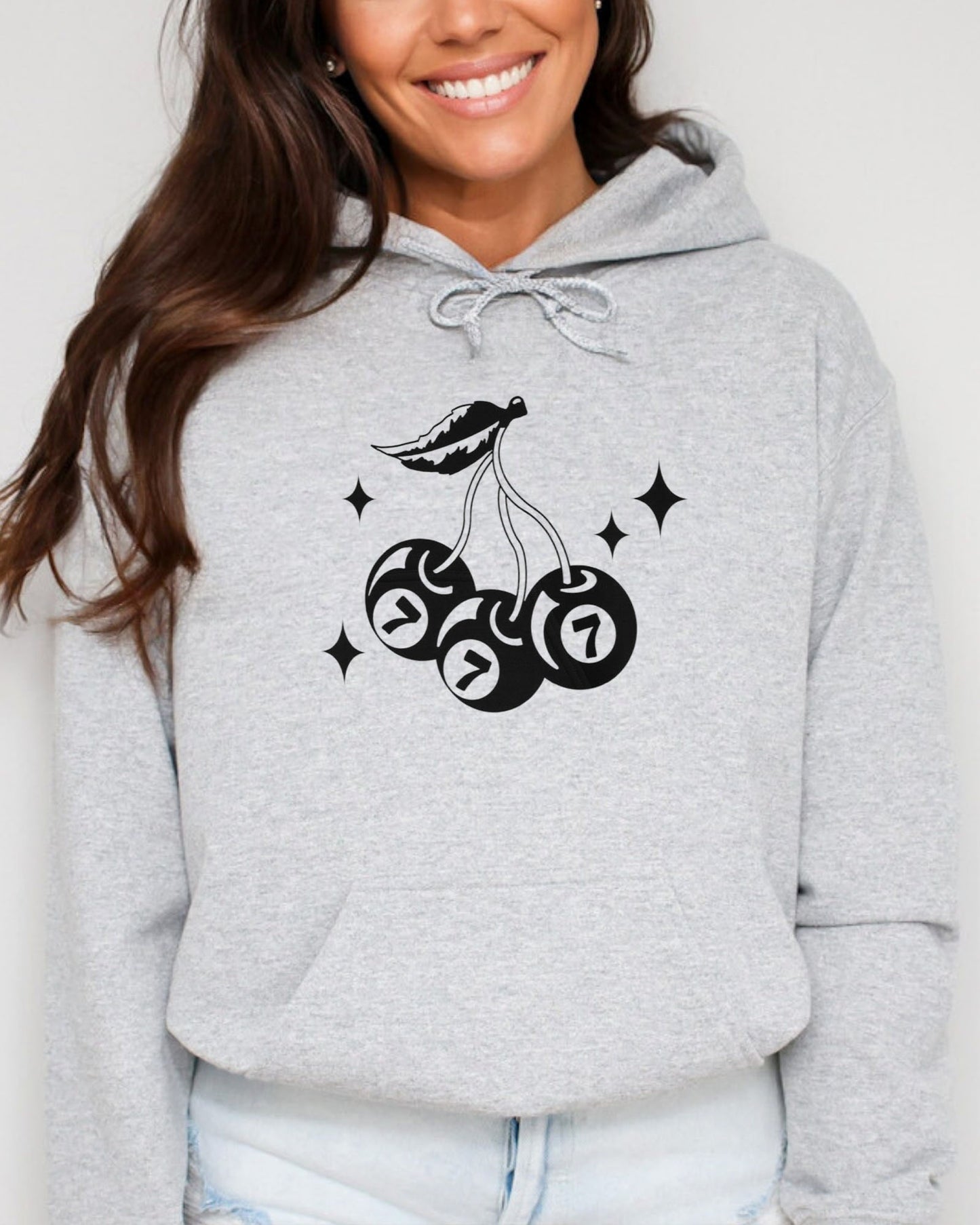 Woman wearing sport gray hoodie featuring a retro lucky 7 eightball cherries graphic.