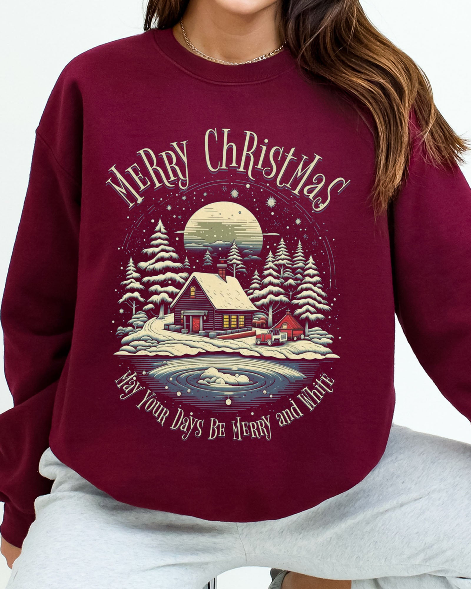 Close-up of a model wearing maroon color sweatshirt with 'May Your Days Be Merry And Bright' Christmas graphic design
