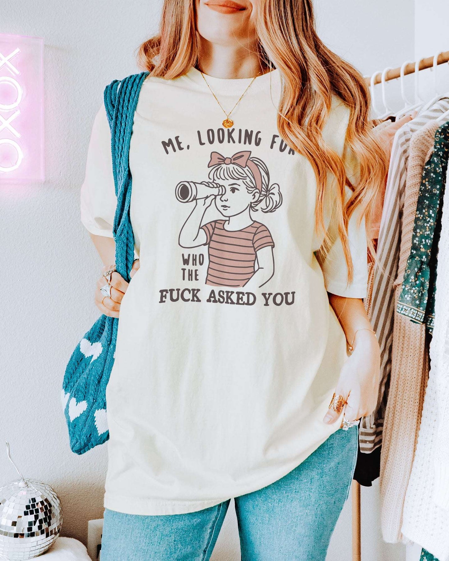 Woman wearing ivory color shirt with 'Me, Looking For Who The Fuck Asked You' graphic design