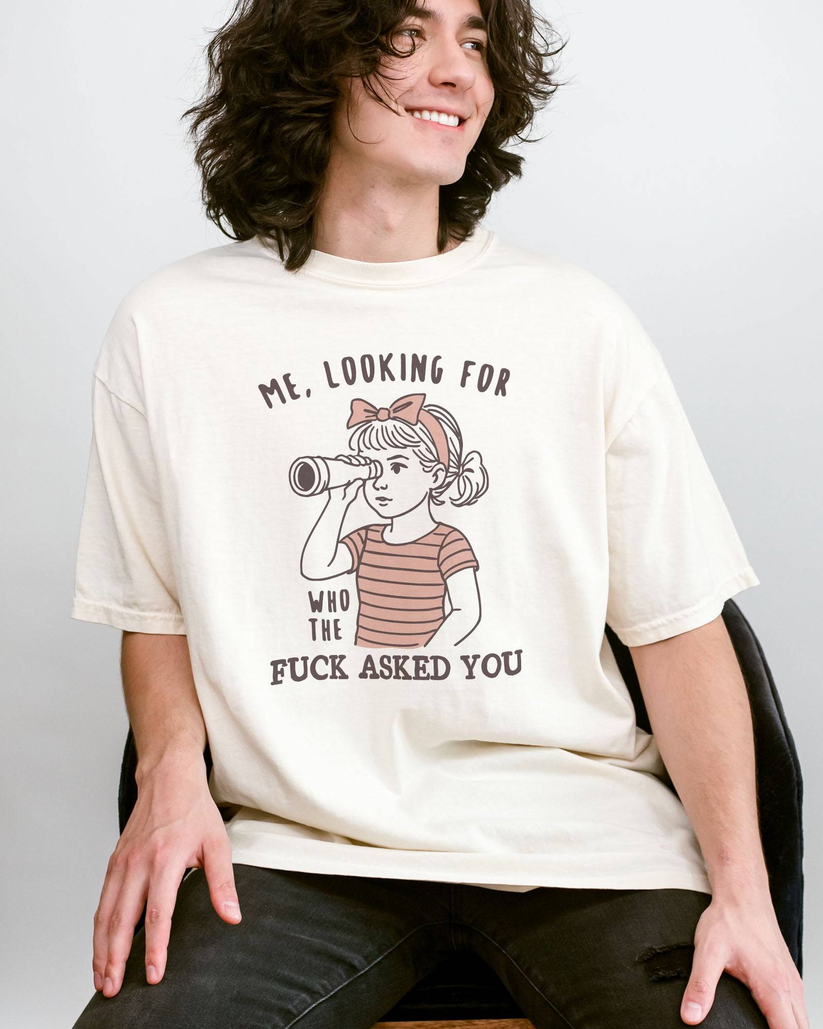 Man wearing ivory color shirt with 'Me, Looking For Who The Fuck Asked You' graphic design