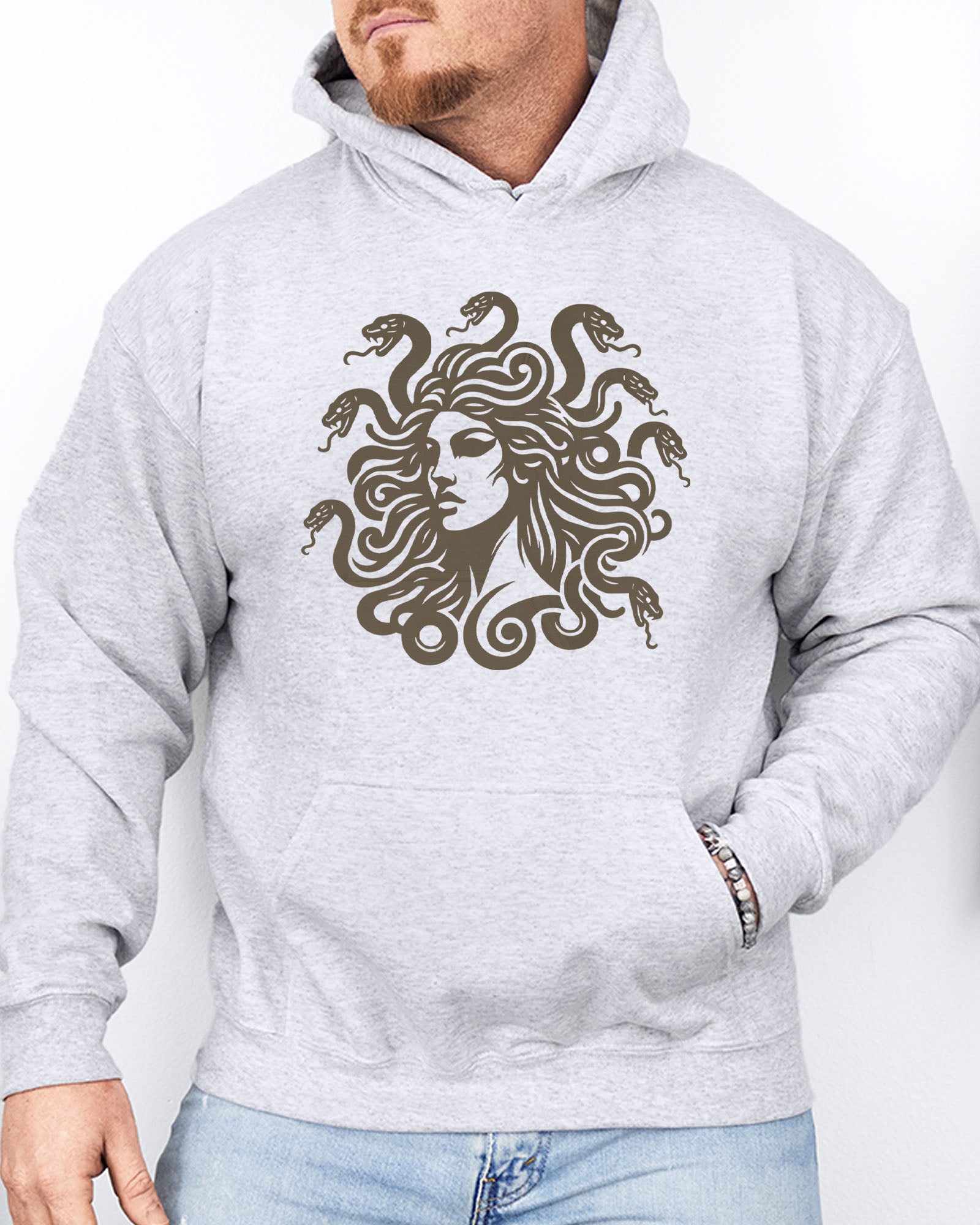 Man wearing an ash gray hoodie featuring a vintage-style Medusa graphic with snake hair.