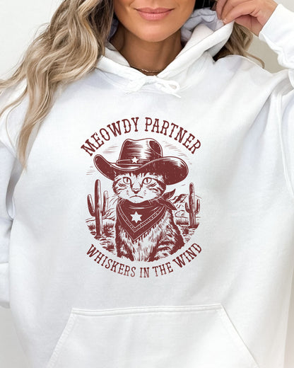 Close-up of a white hoodie with a funny retro cowboy cat graphic and the text 'Meowdy Partner, Whiskers in the Wind' in a western-style design.