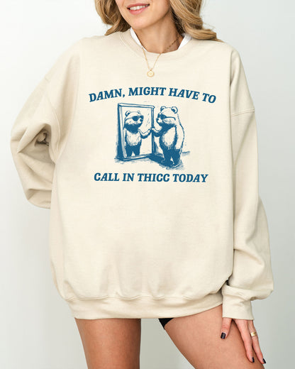 Model wearing sand color sweatshirt with 'Damn, Might Have To Call in Thicc Today' graphic design