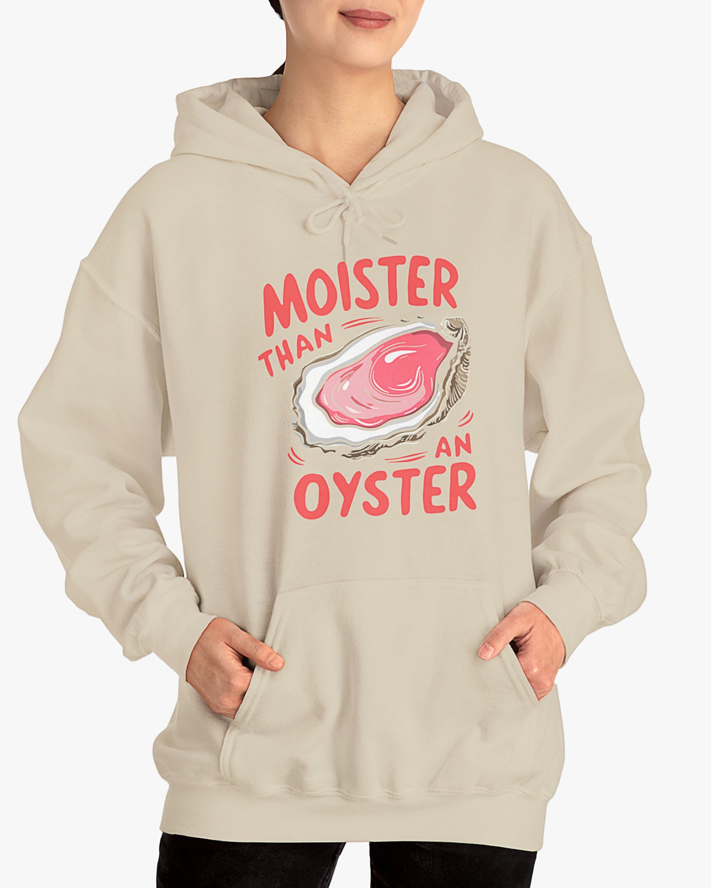 Woman wearing a sand beige 'Moister Than An Oyster' hoodie featuring a funny oyster graphic.