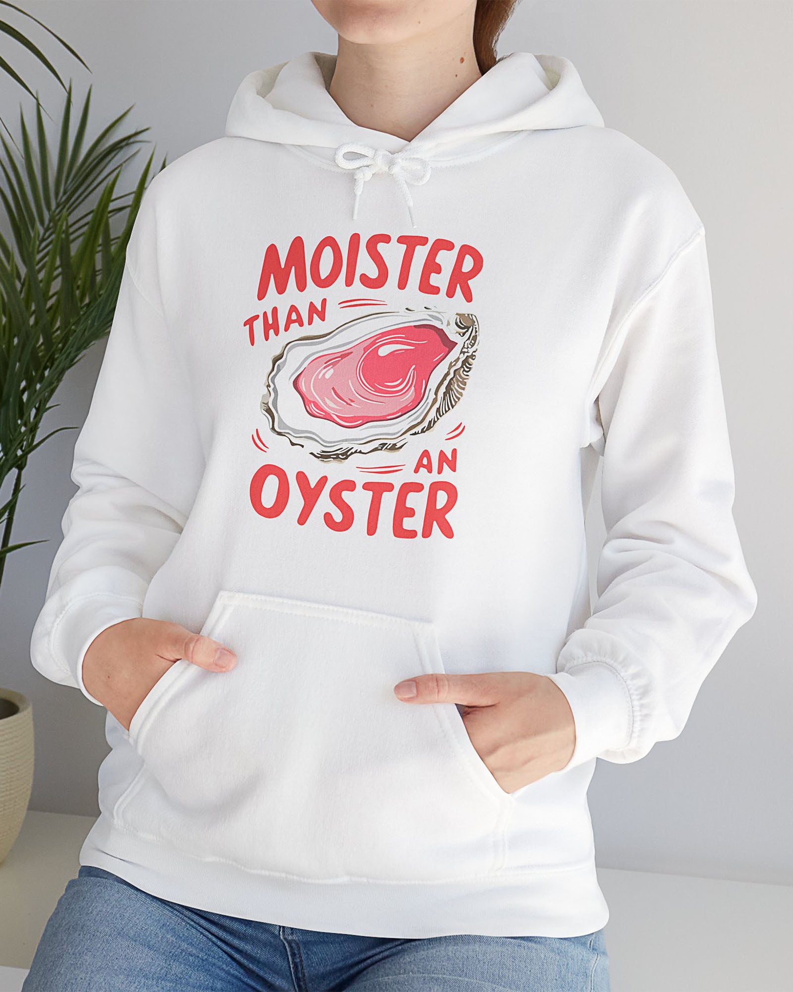 Woman wearing a white 'Moister Than An Oyster' hoodie featuring a funny oyster graphic.