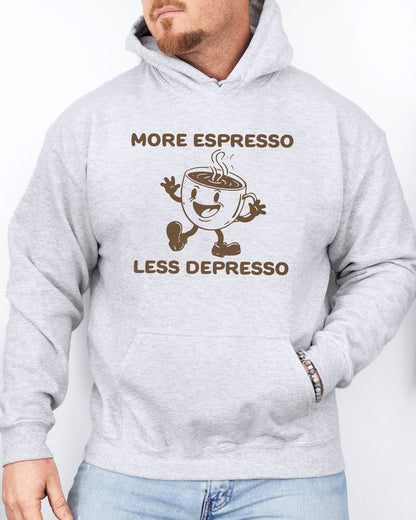 Man wearing an ash gray hoodie with a funny retro-style coffee mug character and the quote 'More Espresso Less Depresso' in bold lettering.