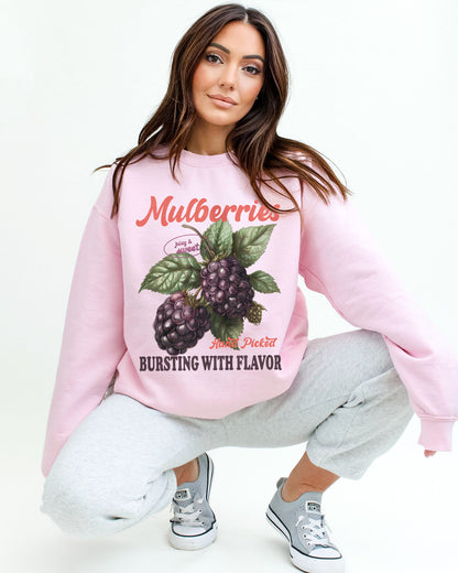 Model wearing light pink color sweatshirt with mulberries fruit graphic design
