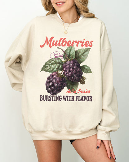 Model wearing sand color sweatshirt with mulberries fruit graphic design