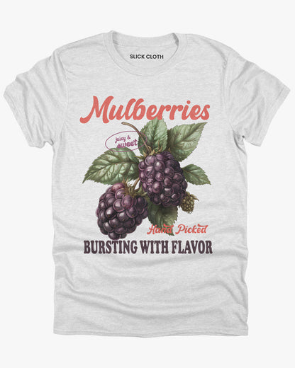 Flat lay of a ash gray t-shirt featuring a retro fruit graphic with the quote 'Mulberries - Bursting With Flavor.'