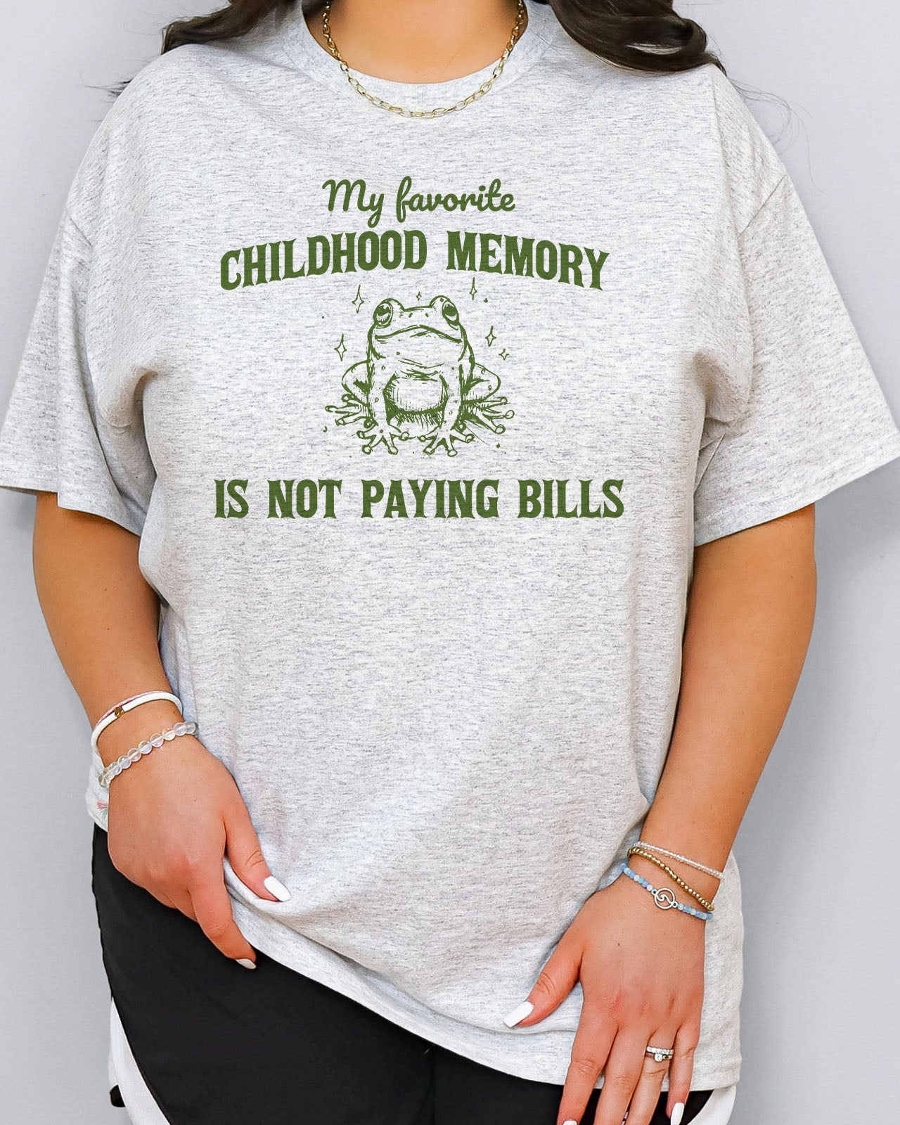 Woman wearing a funny shirt in ash grey color with the quote "My Favorite Childhood Memory Is Not Paying Bills"