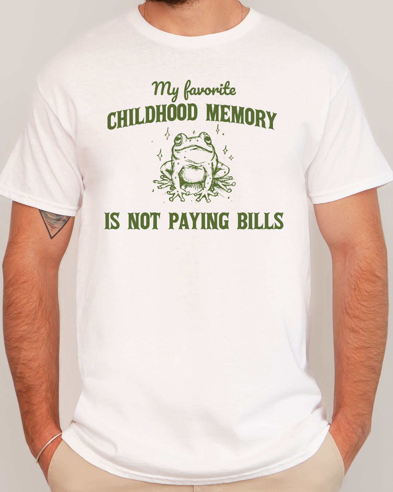 Man wearing a funny shirt in white color with the quote "My Favorite Childhood Memory Is Not Paying Bills"