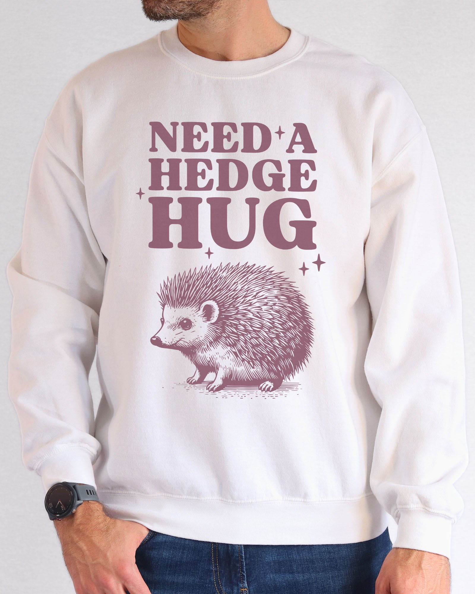 Model wearing white color sweatshirt with 'Need A Hedge Hug' graphic design