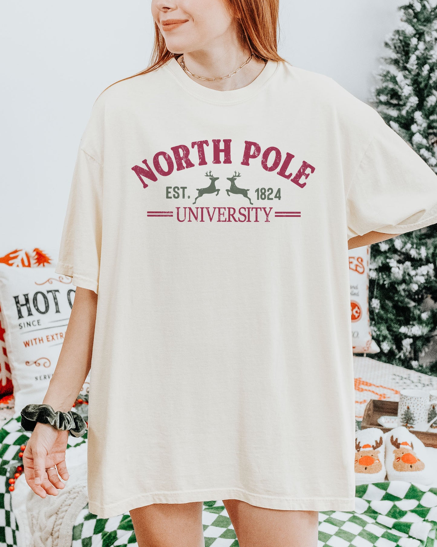 Woman wearing an ivory "North Pole University" shirt.