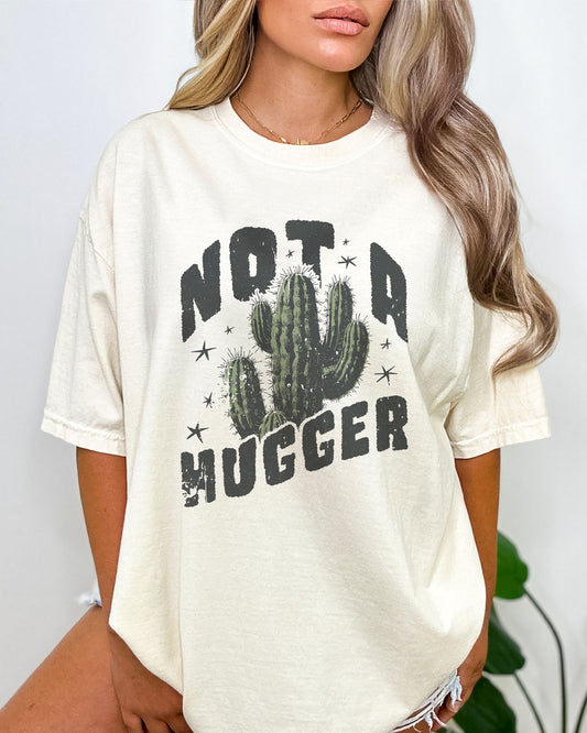 Model wearing natural color shirt with 'Not A Hugger' cactus graphic design