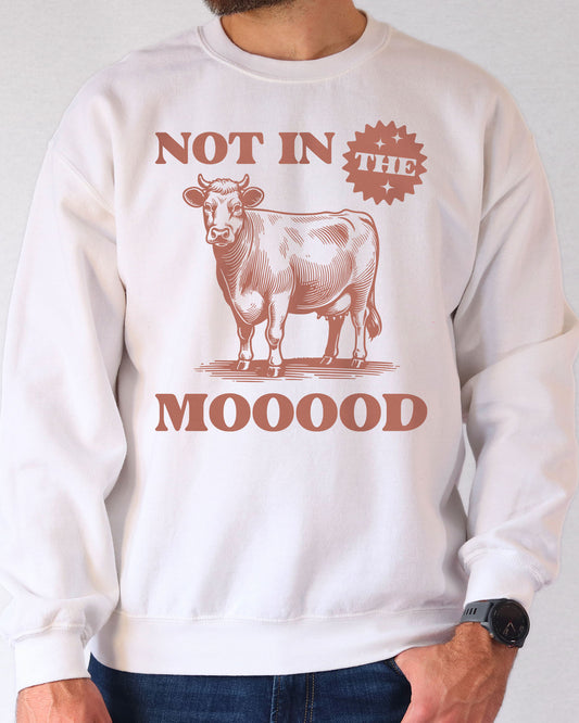 Man wearing a white sweatshirt featuring a retro cow grahic and the quote 'Not In The Mooood'.