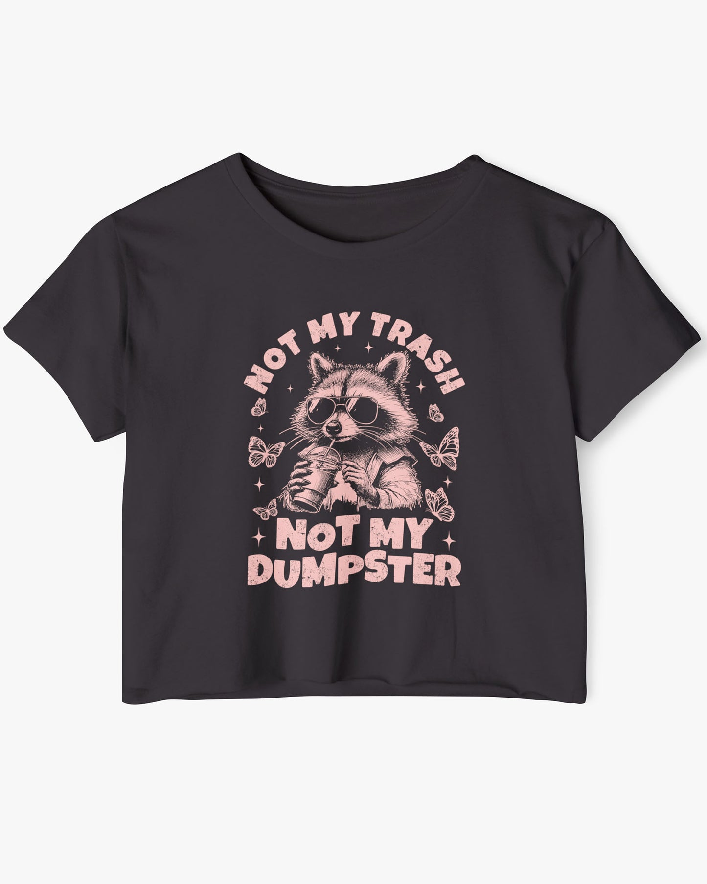 Flat lay of a black 'Not My Trash Not My Dumpster' crop top featuring a funny retro raccoon drinking coffee graphic.