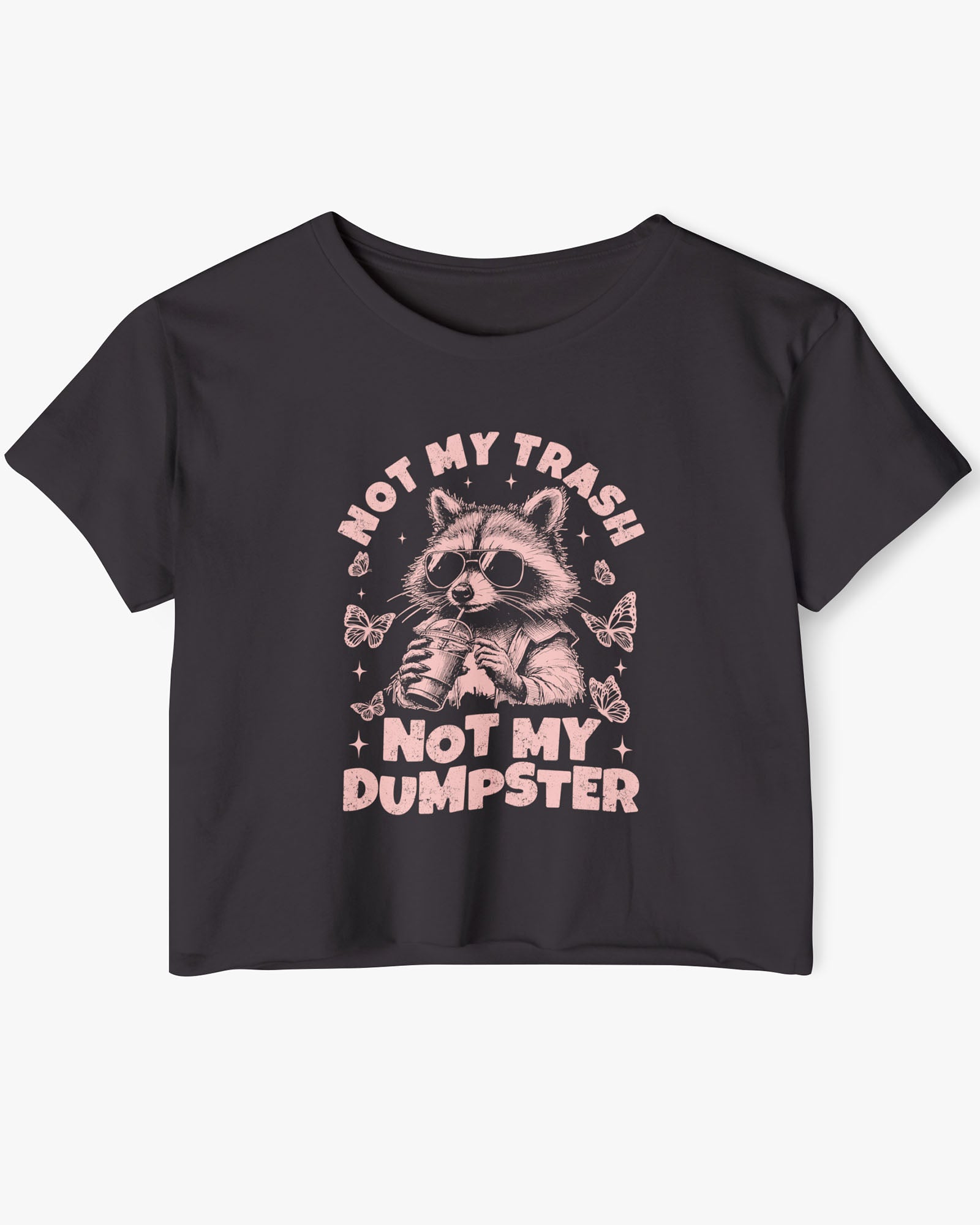 Flat lay of a black 'Not My Trash Not My Dumpster' crop top featuring a funny retro raccoon drinking coffee graphic.