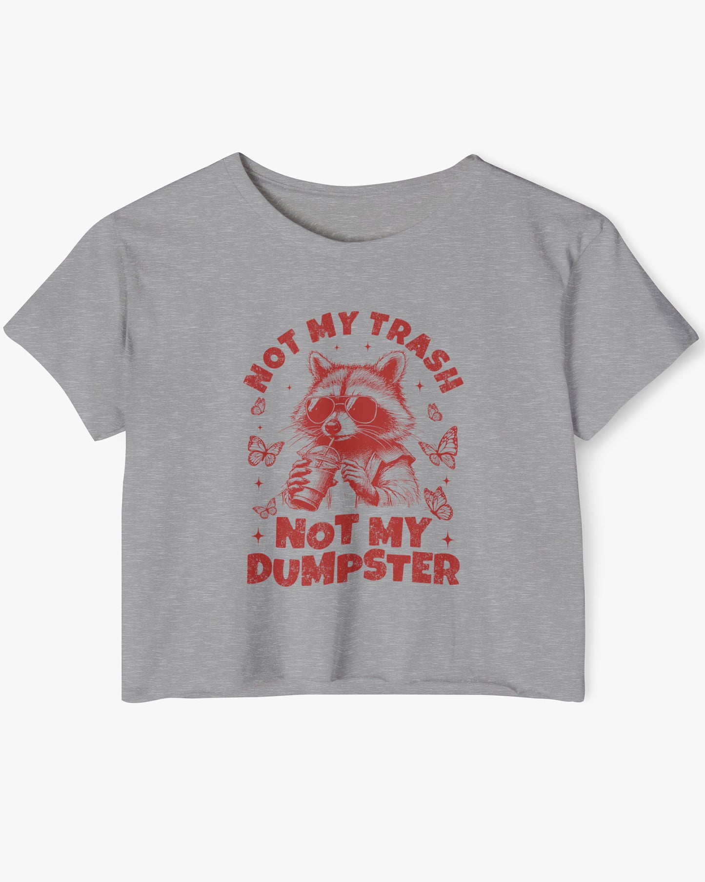 Flat lay of a heather gray 'Not My Trash Not My Dumpster' crop top featuring a funny retro raccoon drinking coffee graphic.