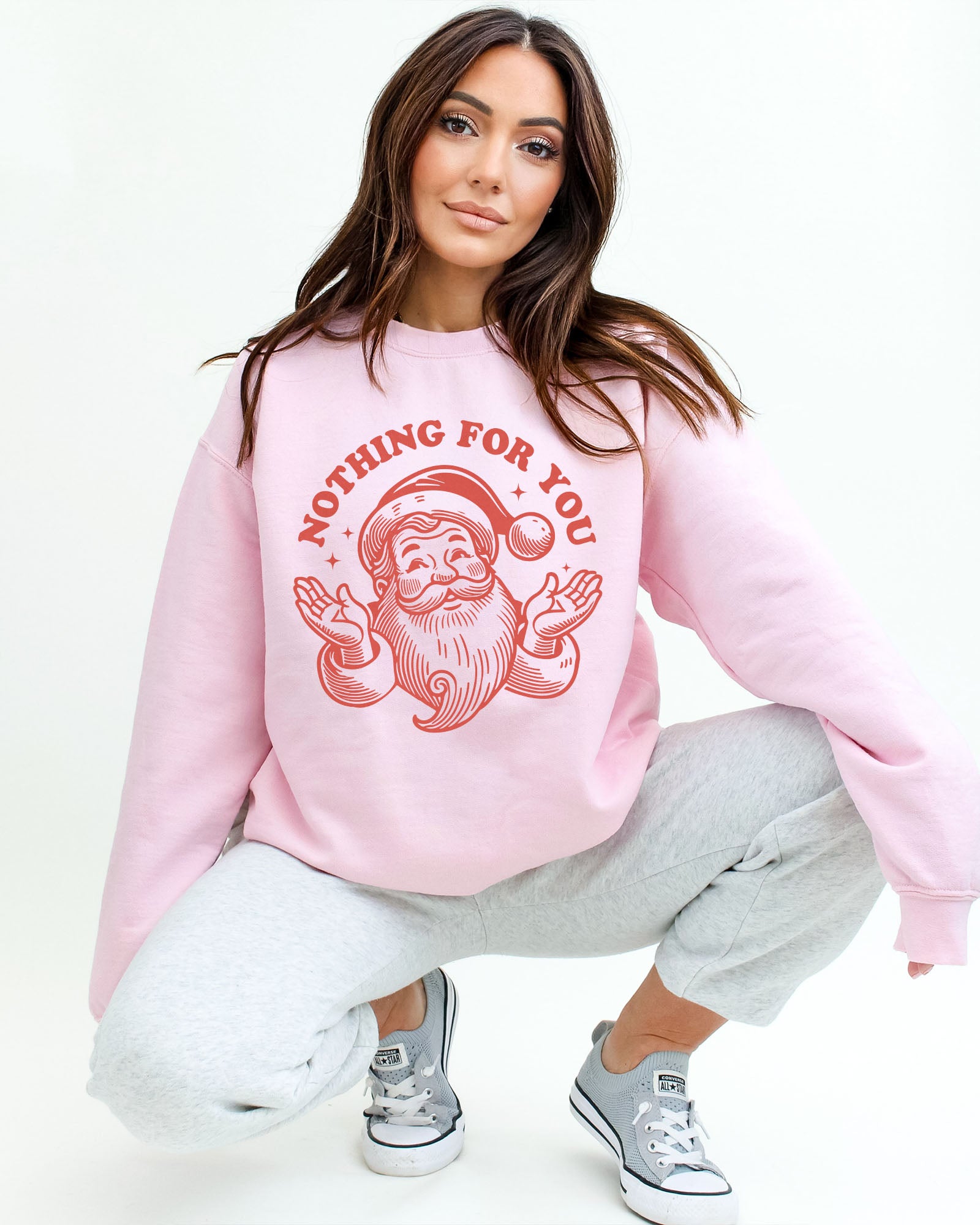Model wearing light pink color sweatshirt with 'Nothing For You' Santa Claus graphic design