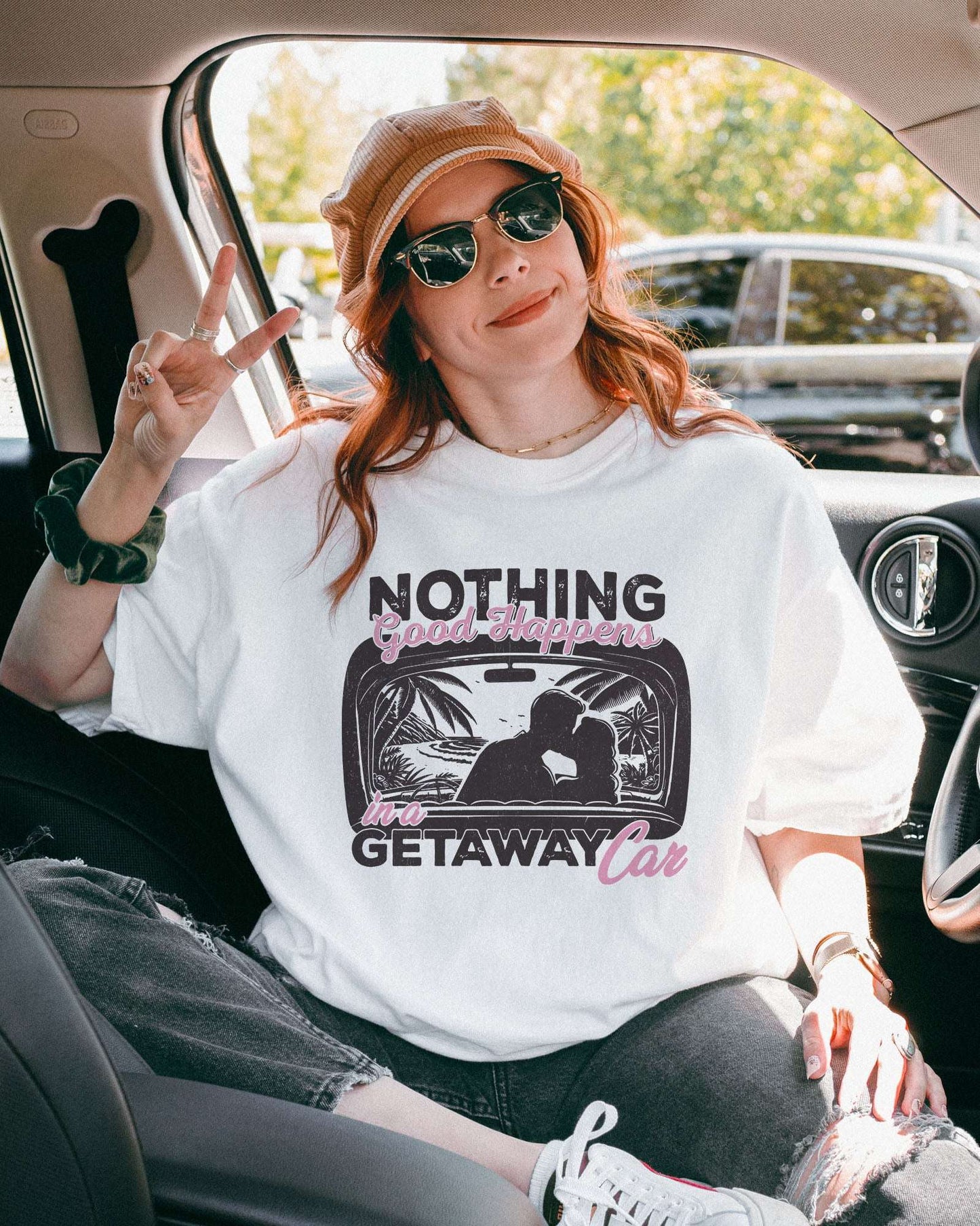 Model wearing white color shirt with 'Nothing Good Happens In A Getaway Car' graphic design