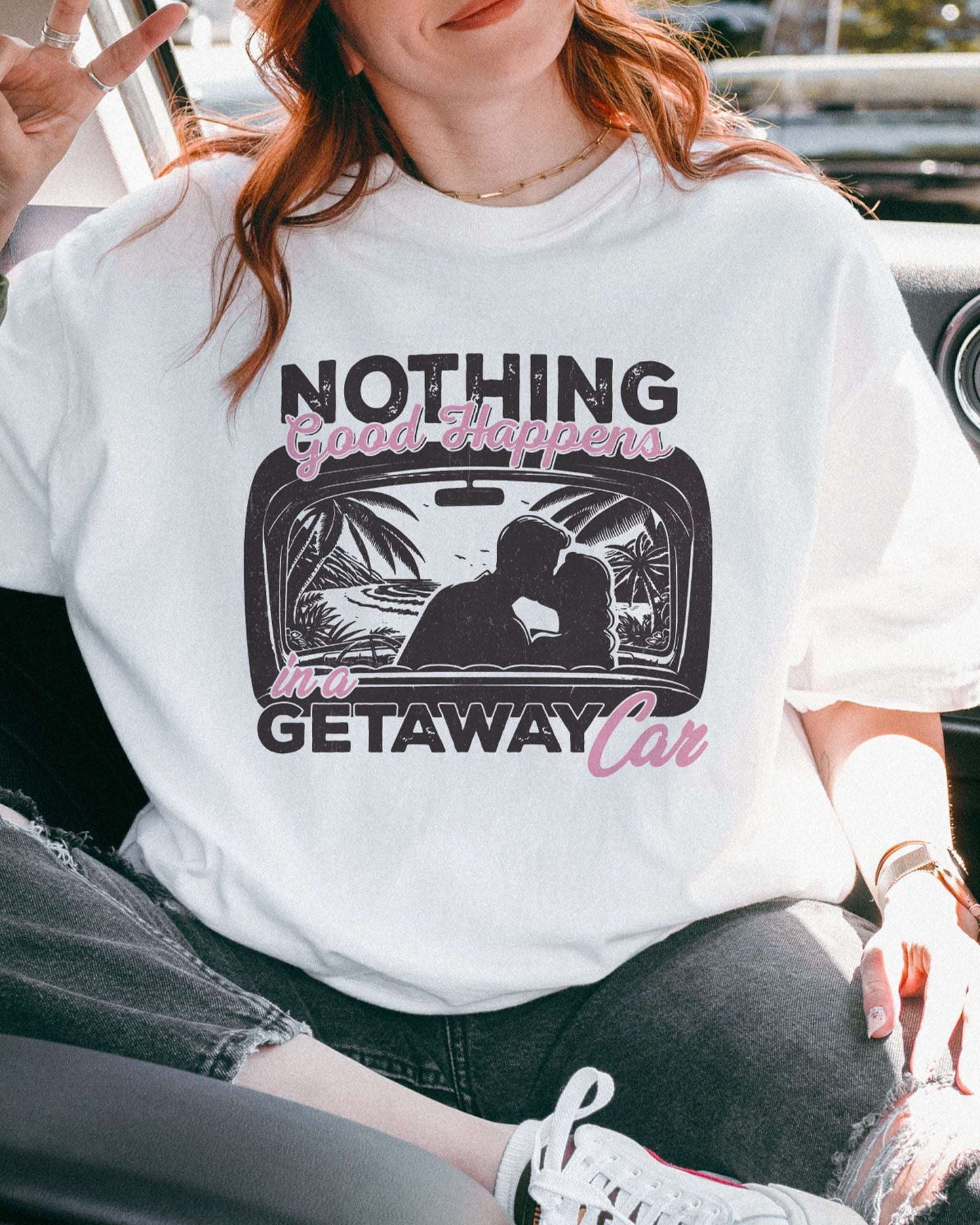Close-up of model wearing white color shirt with 'Nothing Good Happens In A Getaway Car' graphic design