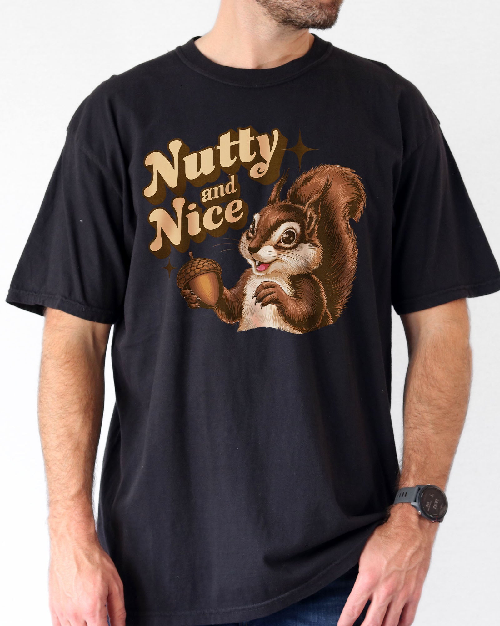 Man wearing a black ‘Nutty and Nice’ shirt with a retro graphic of a squirrel.