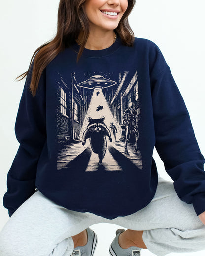 Woman wearing a navy blue sweatshirt with a retro graphic of a raccoon running from aliens.