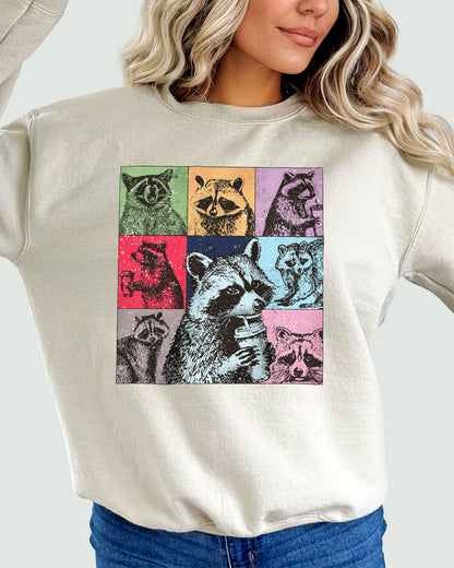Woman wearing a sweatshirt in sandy beige, featuring a retro raccoons drinking coffee collage graphic design and unisex fit.
