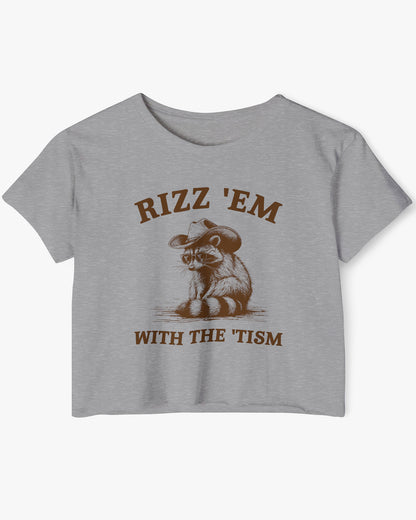 Flat lay heather gray 'Rizz Em With The Tism' crop top featuring a funny retro cowboy raccoon graphic.