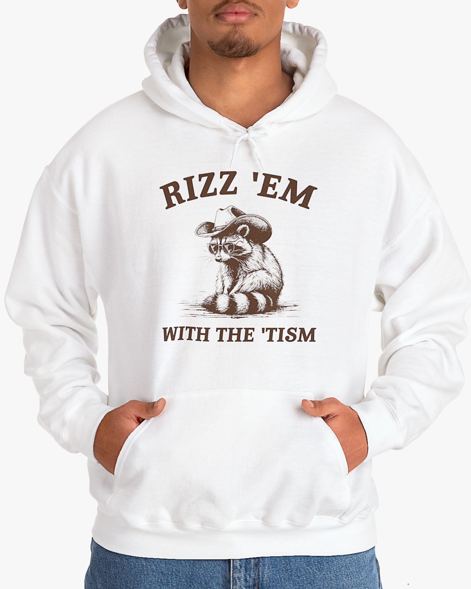 Man wearing a white Rizz ‘Em With The Tism Hoodie, featuring a retro cowboy raccoon graphic with a funny slogan.