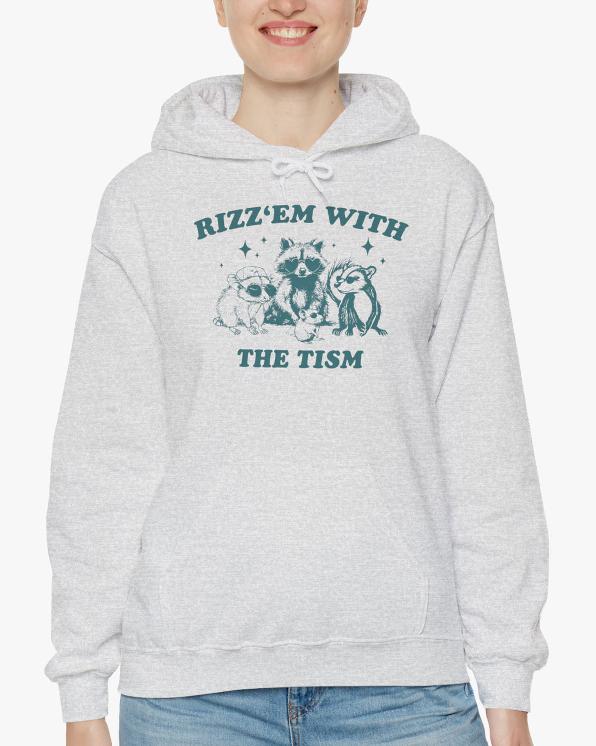 Woman wearing a 'Rizz Em With The Tism' hoodie in ash gray, featuring a retro western graphic design and unisex fit.