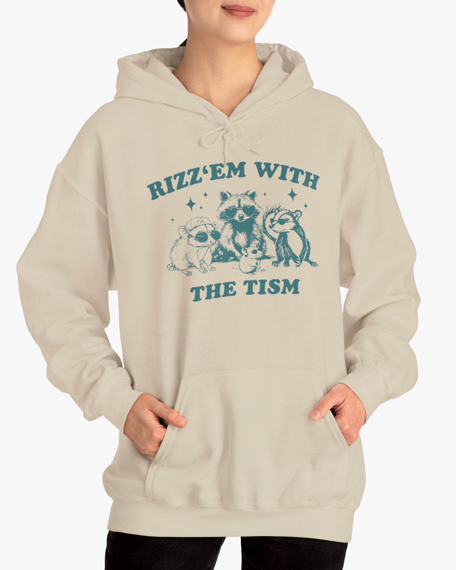 Woman wearing a 'Rizz Em With The Tism' hoodie in sand beige, featuring a retro western graphic design and unisex fit.