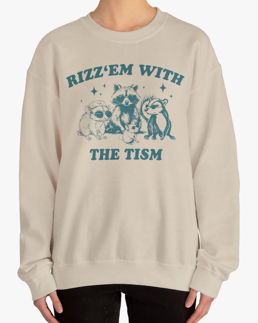 Man wearing a 'Rizz Em With The Tism' sweatshirt in sand beige, featuring a retro raccoon gang graphic design and unisex fit.
